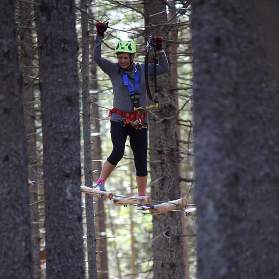 Femme sur un pont suspendu dans les arbres