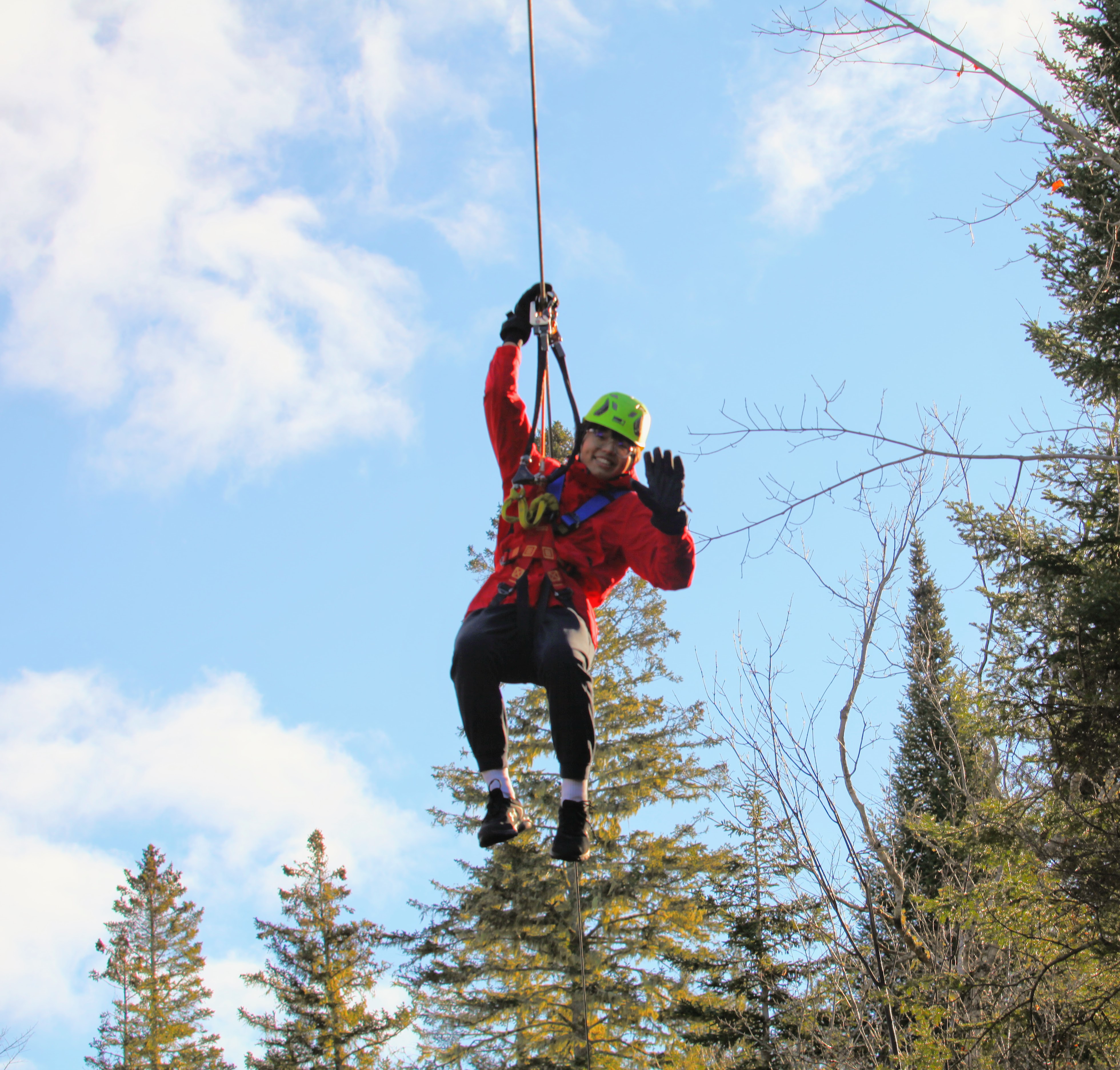 Scout member navigating hanging logs